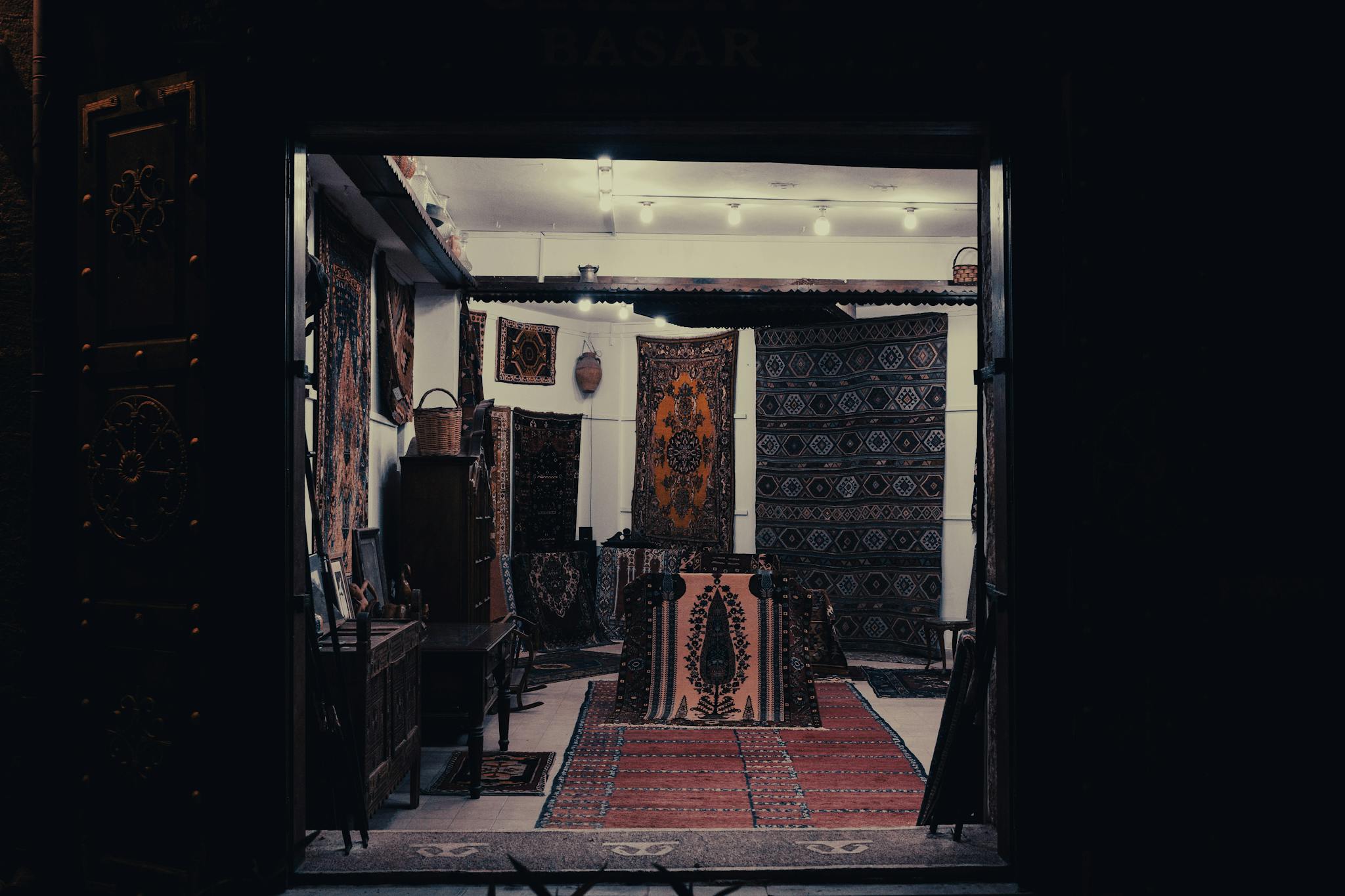 Explore the warm decor of a traditional carpet shop with intricate rugs displayed.